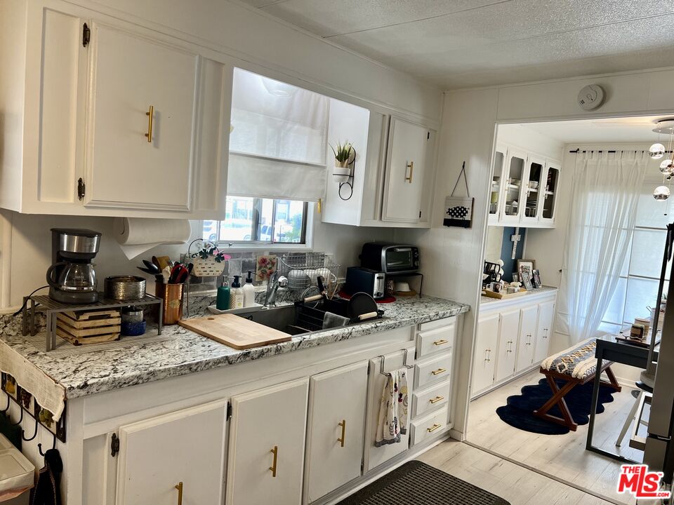 2744 West Rialto Avenue, Unit 49 Rialto, CA 92376 - Photo 8 of 40 a kitchen with granite countertop a sink a stove and cabinets