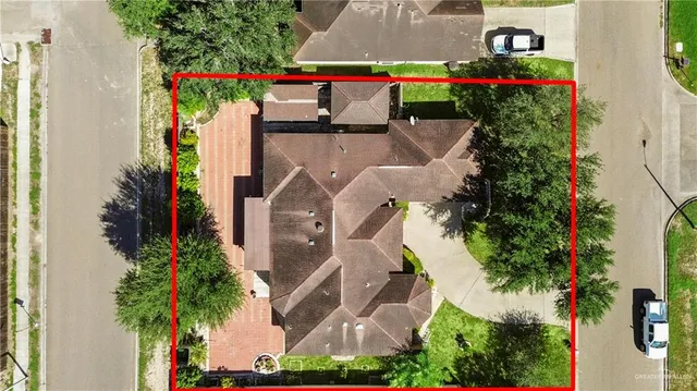 an aerial view of residential houses with outdoor space and trees