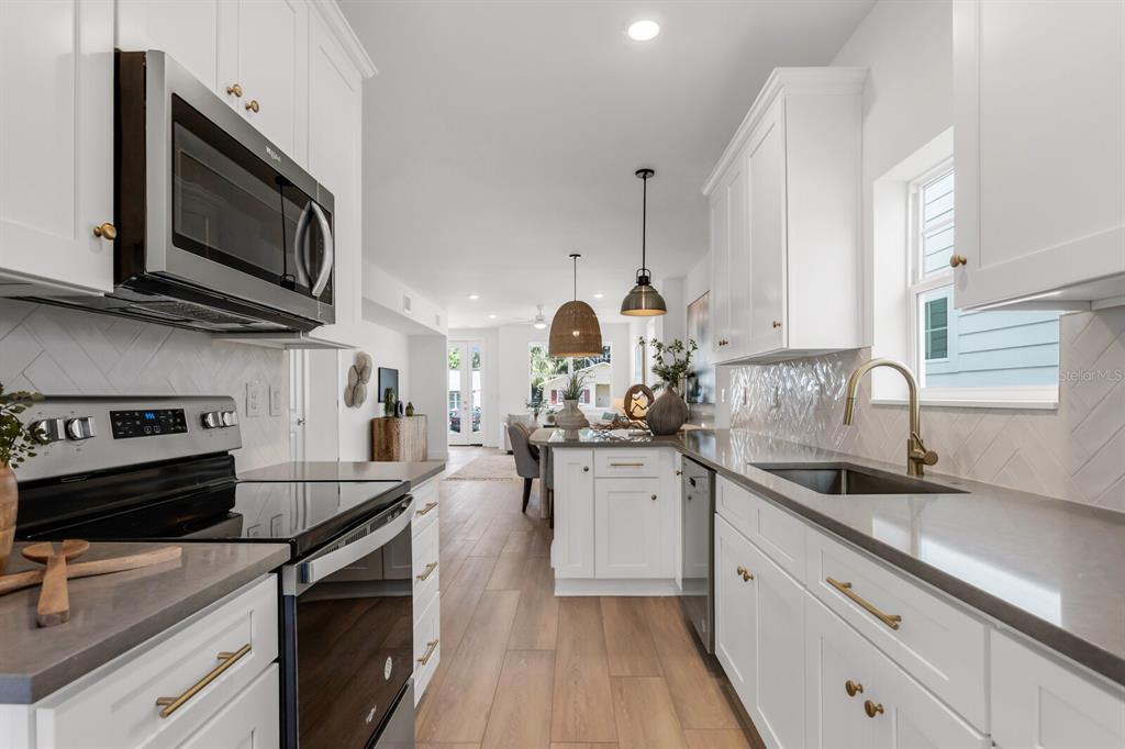 1912 West Chestnut Street Tampa, FL 33607 - Photo 11 of 30 a kitchen with stainless steel appliances a sink dishwasher stove microwave and cabinets