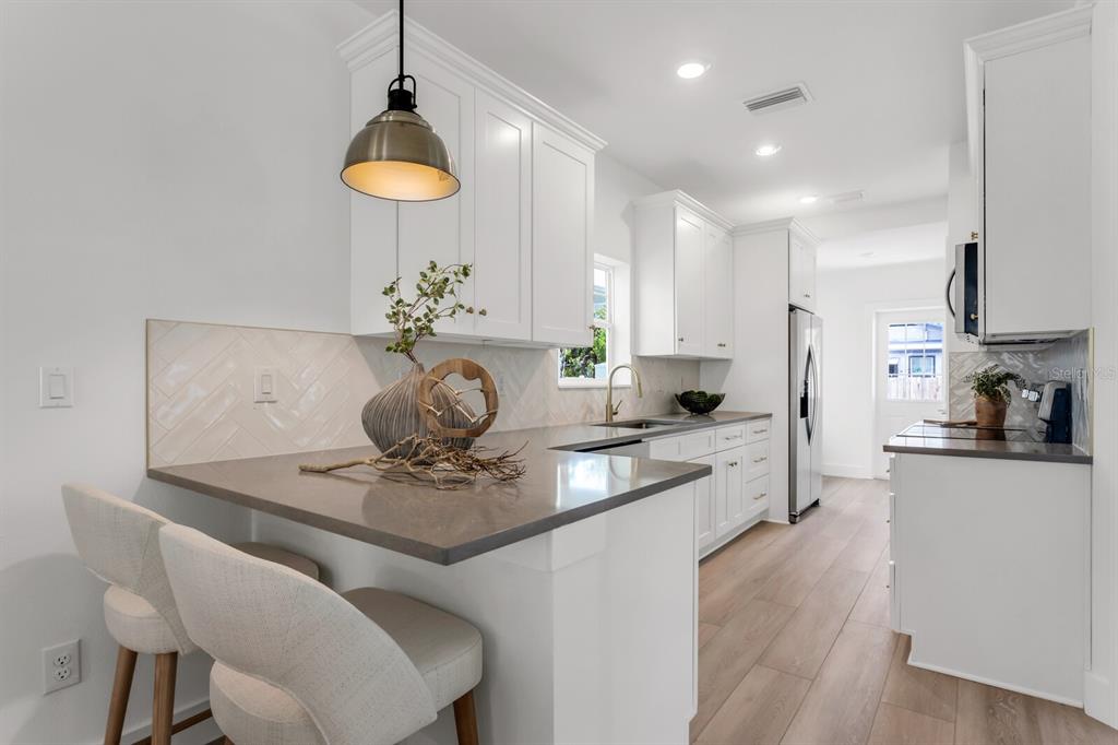 1912 West Chestnut Street Tampa, FL 33607 - Photo 13 of 30 a kitchen with stainless steel appliances granite countertop a kitchen island hardwood floor sink stove dining table and chairs