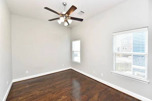 an empty room with a window and a fan