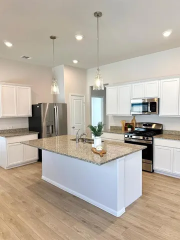 a kitchen with stainless steel appliances kitchen island a sink and a stove