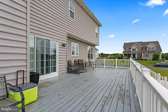 a view of a roof deck with table and chairs a barbeque with wooden floor and fence