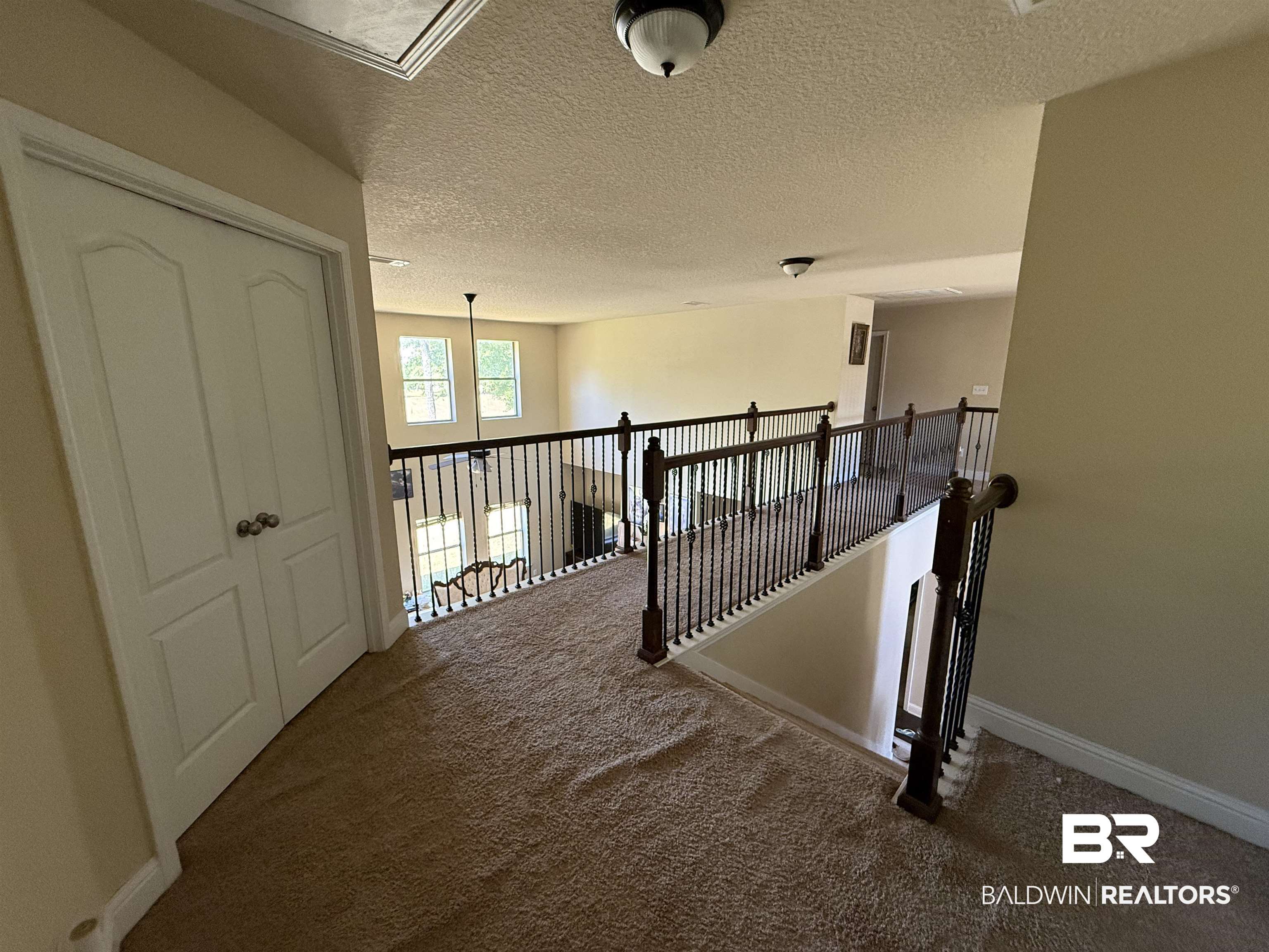 9023 Krystal Ridge Court Daphne, AL 36526 - Photo 30 of 41 Hallway featuring a textured ceiling, carpet, and an upstairs landing