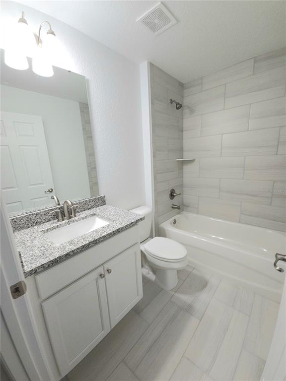 3068 Southwest 131st Place Road Ocala, FL 34473 - Photo 11 of 12 a bathroom with a granite countertop sink a toilet and bathtub