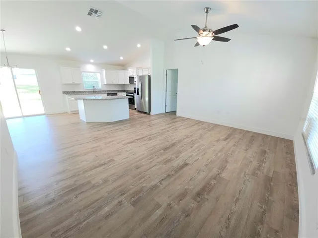 a view of kitchen with granite countertop cabinets and refrigerator