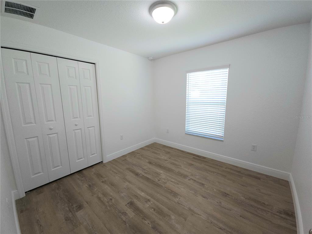 3068 Southwest 131st Place Road Ocala, FL 34473 - Photo 8 of 12 an empty room with wooden floor and windows