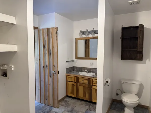 a bathroom with a toilet sink and mirror