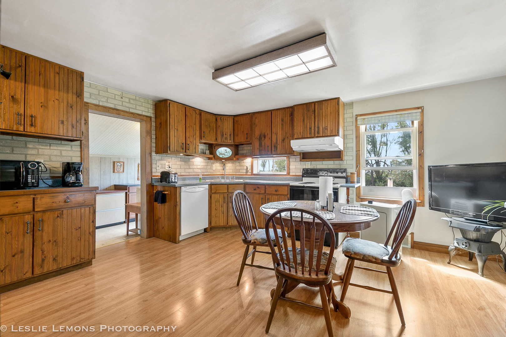 16276 Willrett Road Malta, IL 60150 - Photo 8 of 25 a kitchen with stainless steel appliances granite countertop a stove a refrigerator a microwave oven with a dining table and chairs