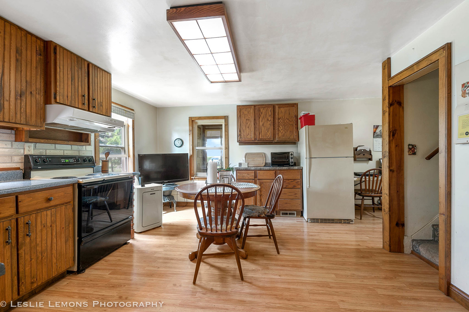 16276 Willrett Road Malta, IL 60150 - Photo 10 of 25 a kitchen with stainless steel appliances granite countertop a refrigerator a stove top oven a sink dishwasher and a dining table with wooden floor