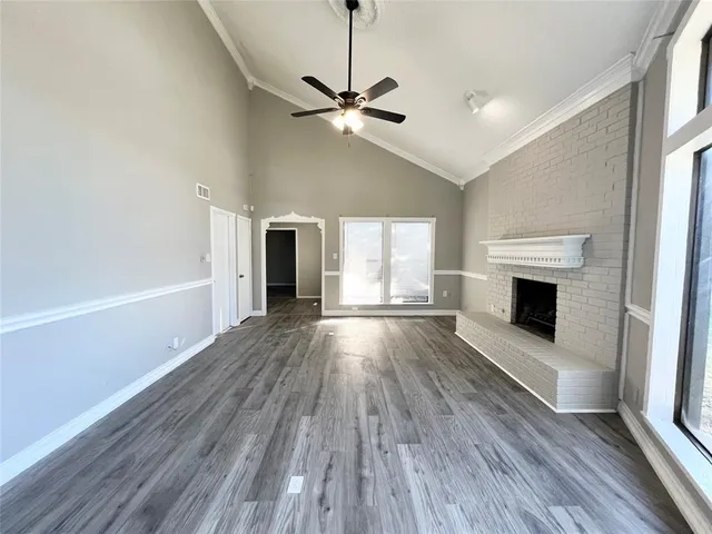 a view of a livingroom with wooden floor and a fireplace