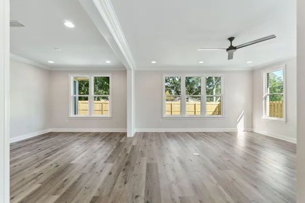 an empty room with wooden floor and windows