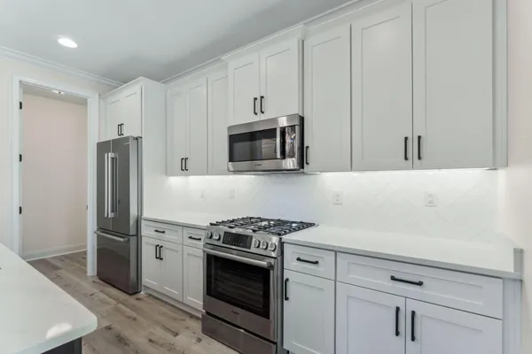 a kitchen with stainless steel appliances white cabinets and stove