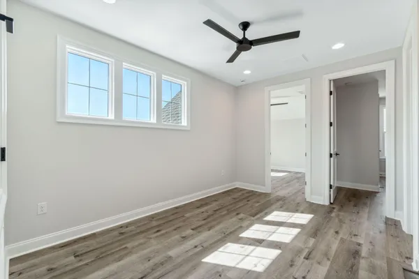 a view of a big room with wooden floor and windows