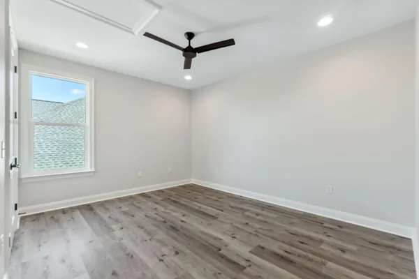 an empty room with a window and a ceiling fan