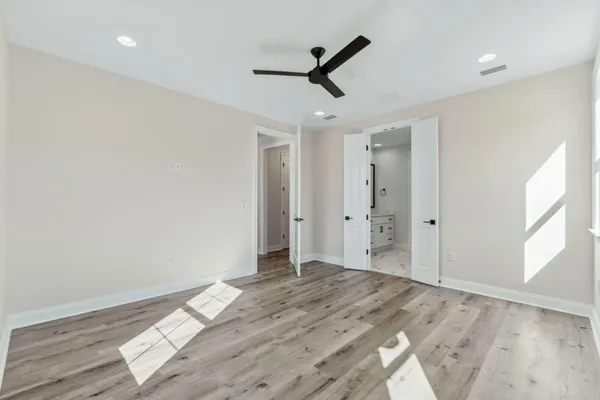 a view of a livingroom with wooden floor and a ceiling fan