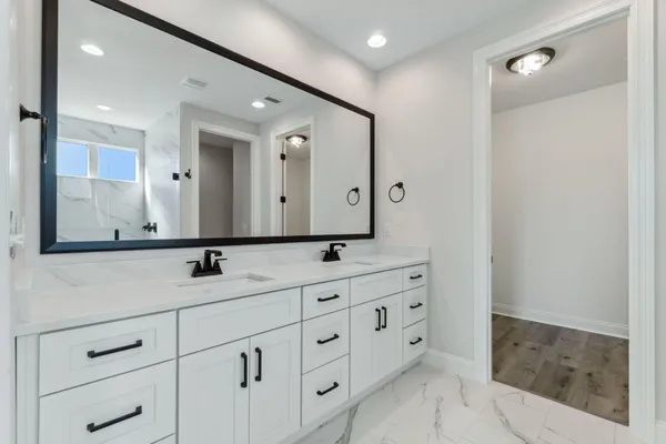 a bathroom with a double vanity sink and mirror