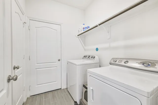 a view of washer and dryer with bathroom in the background