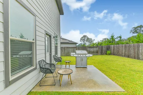 a view of a backyard with table and chairs and wooden fence