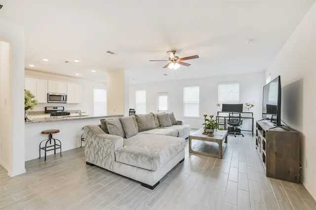 a living room with furniture kitchen view and a flat screen tv