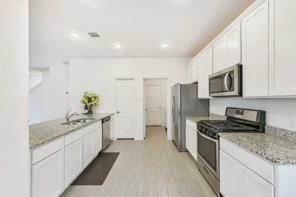 a kitchen with stainless steel appliances granite countertop a sink stove and refrigerator