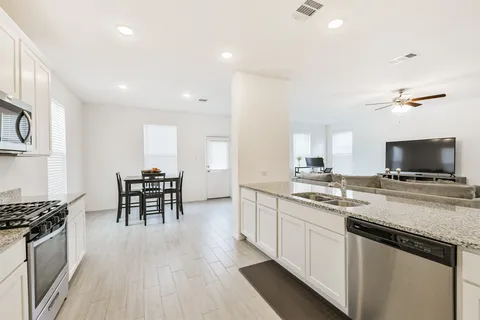 a kitchen with a sink and chairs