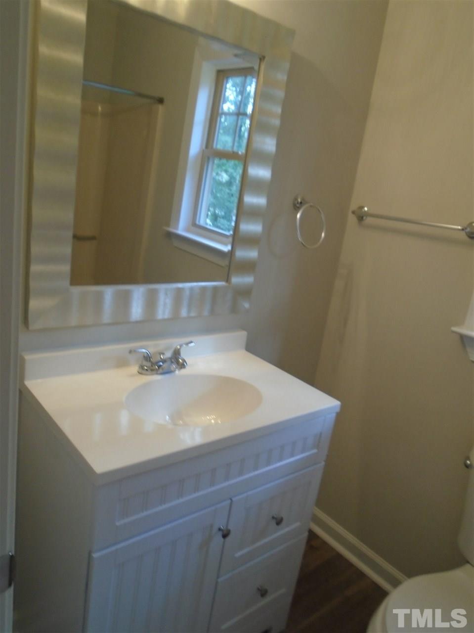 3241 Banks Road Raleigh, NC 27603 - Photo 17 of 19 a bathroom with a sink a toilet and a mirror