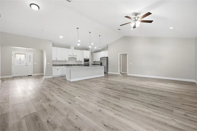 an open kitchen with a refrigerator and a fireplace
