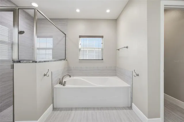 a white bath tub sitting next to a shower