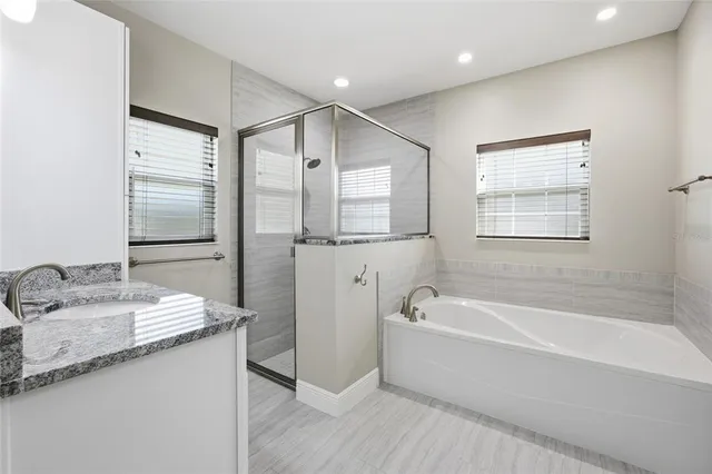 a spacious bathroom with a tub sink and mirror