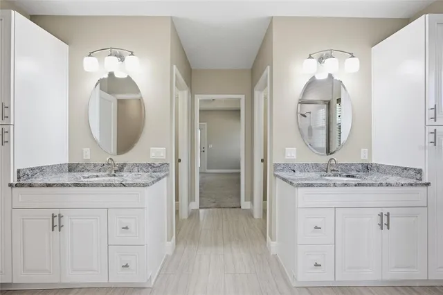 a en suite bathroom with a granite countertop sink and a mirror