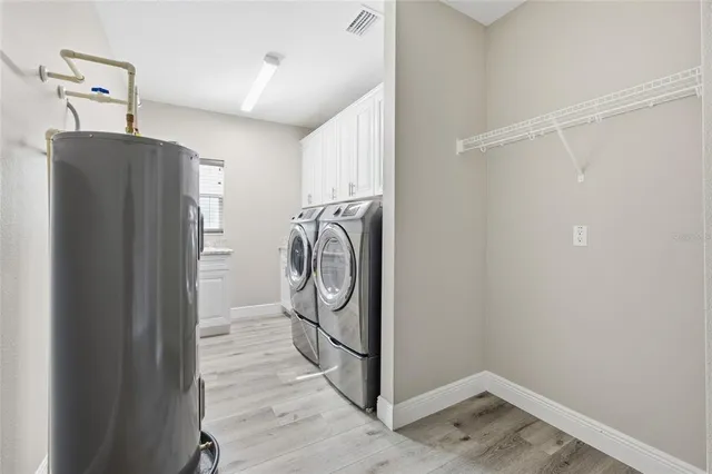 a utility room with wooden floor washer and dryer