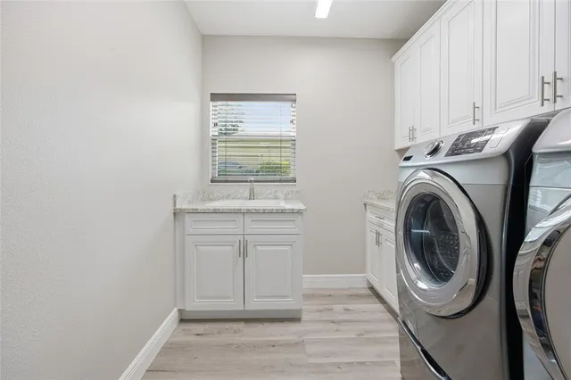 a utility room with sink dryer and washer