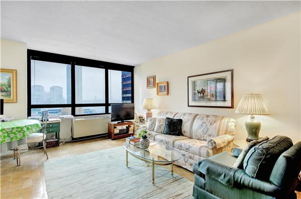630 1st Avenue, Unit 21M Manhattan, NY 10016 - Photo 1 of 1 a living room with furniture and a large window