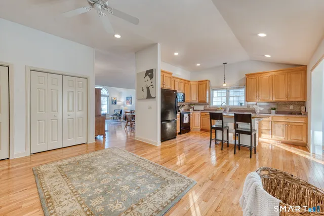 a view of a kitchen with kitchen island granite countertop wooden floor and stainless steel appliances