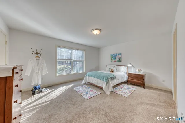 a spacious bedroom with a bed and a window