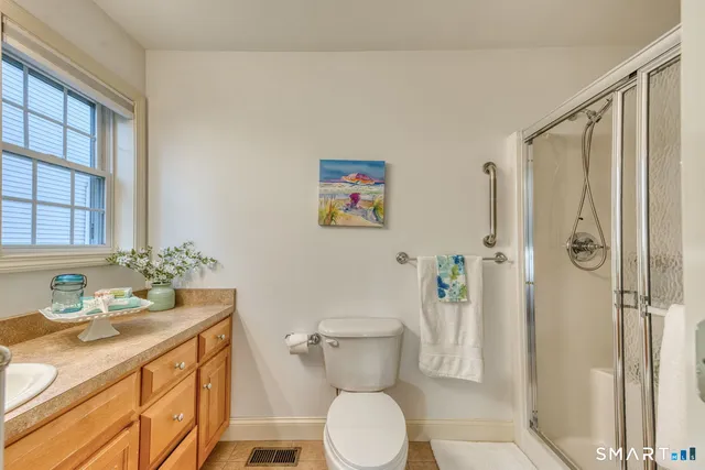 a bathroom with a granite countertop sink toilet and shower