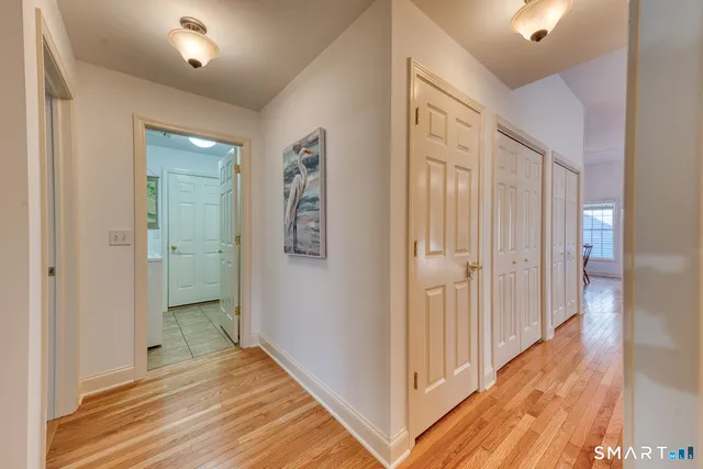 a view of a hallway with wooden floor and closet area