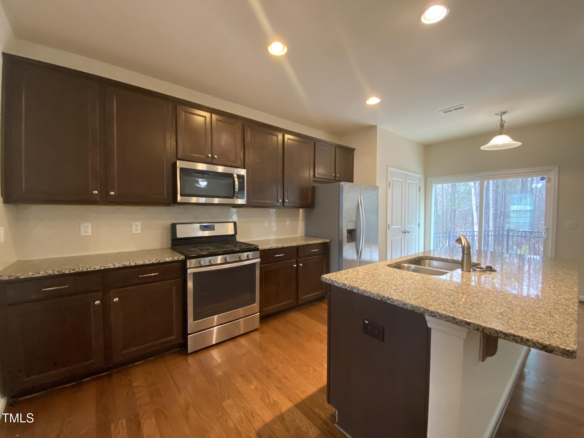 3545 Massey Ridge Court Raleigh, NC 27616 - Photo 7 of 38 a kitchen with stainless steel appliances granite countertop a sink stove and microwave