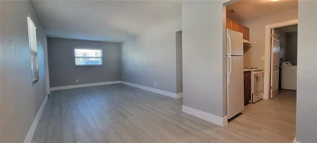 an empty room with wooden floor and a window