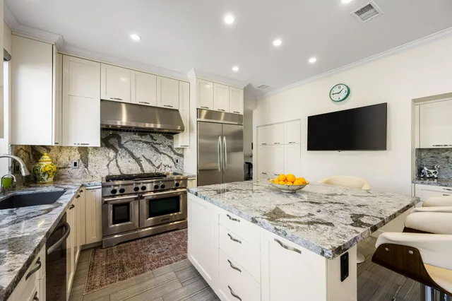 a kitchen with stainless steel appliances kitchen island granite countertop a stove and a sink