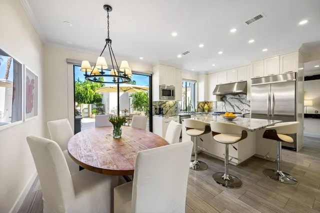 a dining room with furniture a chandelier and wooden floor