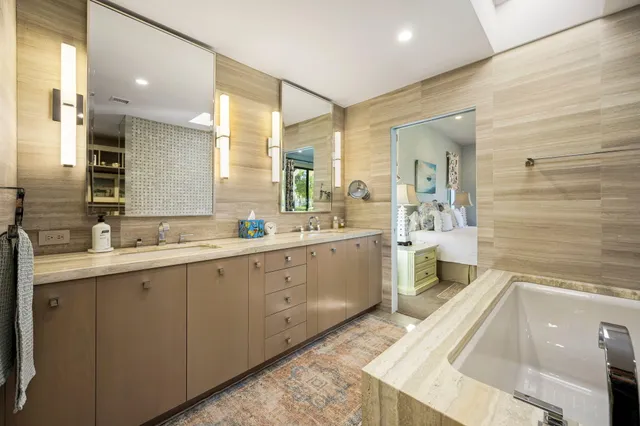 a spacious bathroom with a double vanity sink a mirror and a shower