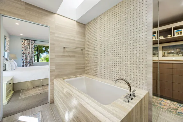 a bathroom with a tub sink and mirror