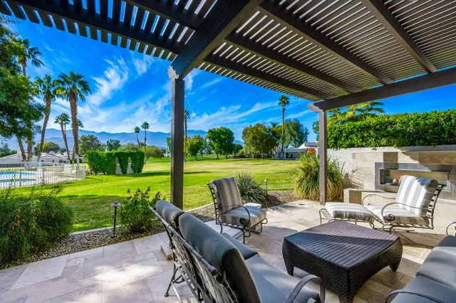 a view of a patio with couches plants and a big yard