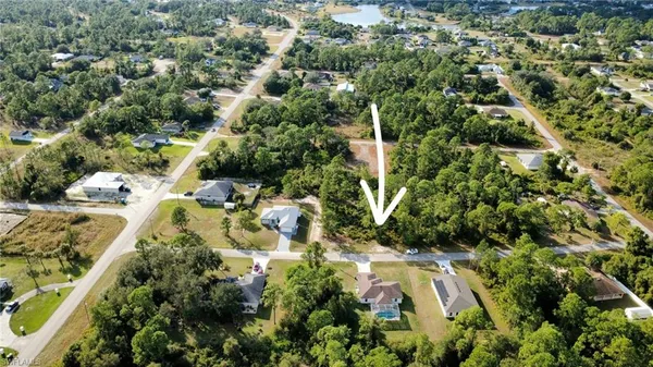 an aerial view of residential house with outdoor space and trees all around
