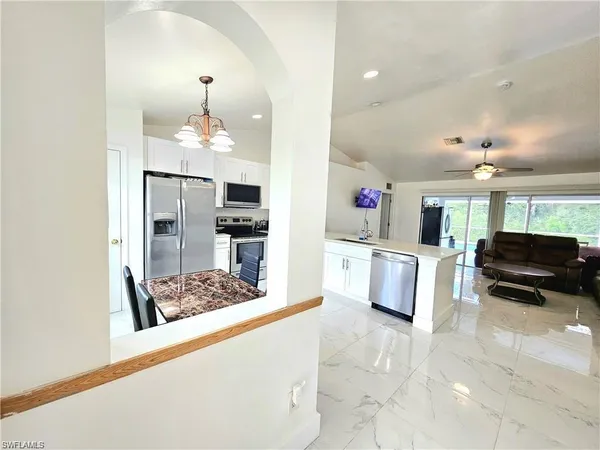 a kitchen with stainless steel appliances kitchen island granite countertop a refrigerator and a stove