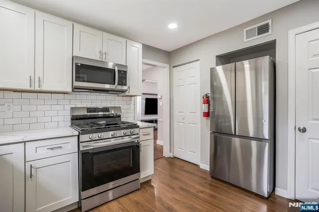 a kitchen with stainless steel appliances a refrigerator stove and microwave
