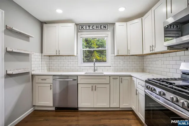 a kitchen with cabinets appliances a sink and a window