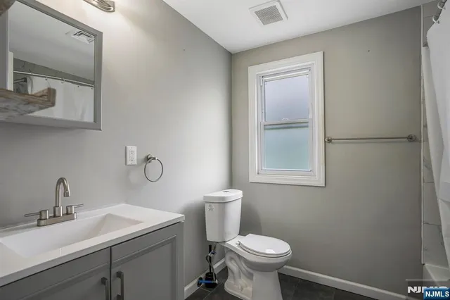 a bathroom with a sink toilet and mirror